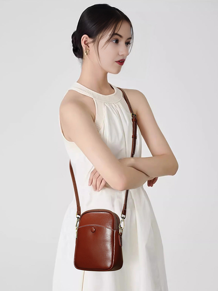 Model wearing caramel cowhide leather mini crossbody bag crossbody style