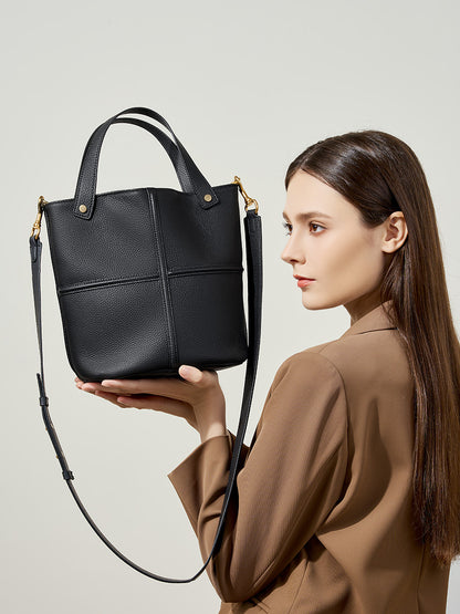 Model holding black bucket bag with detachable strap