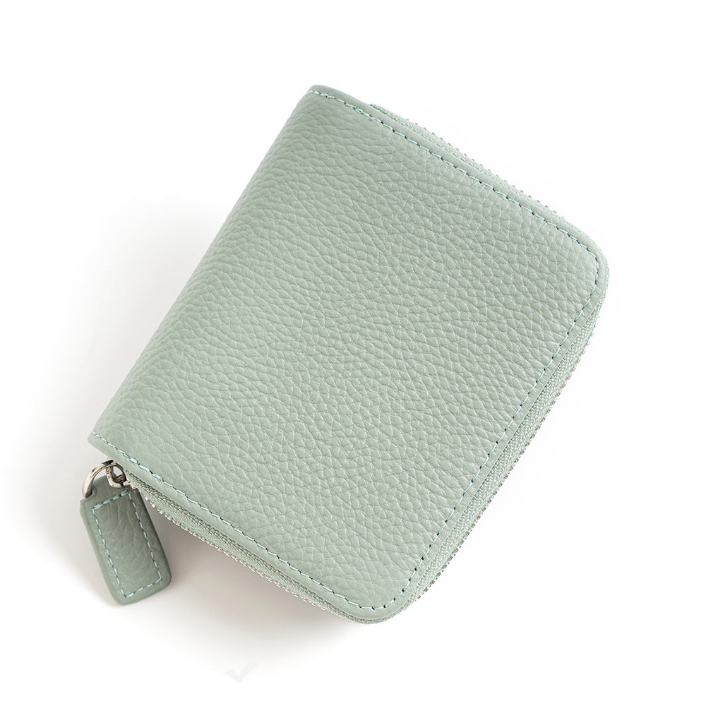 Light green leather wallet with pebbled texture and zipper pull