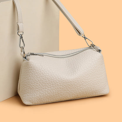 Off-white cowhide crossbody bag with top zipper and strap