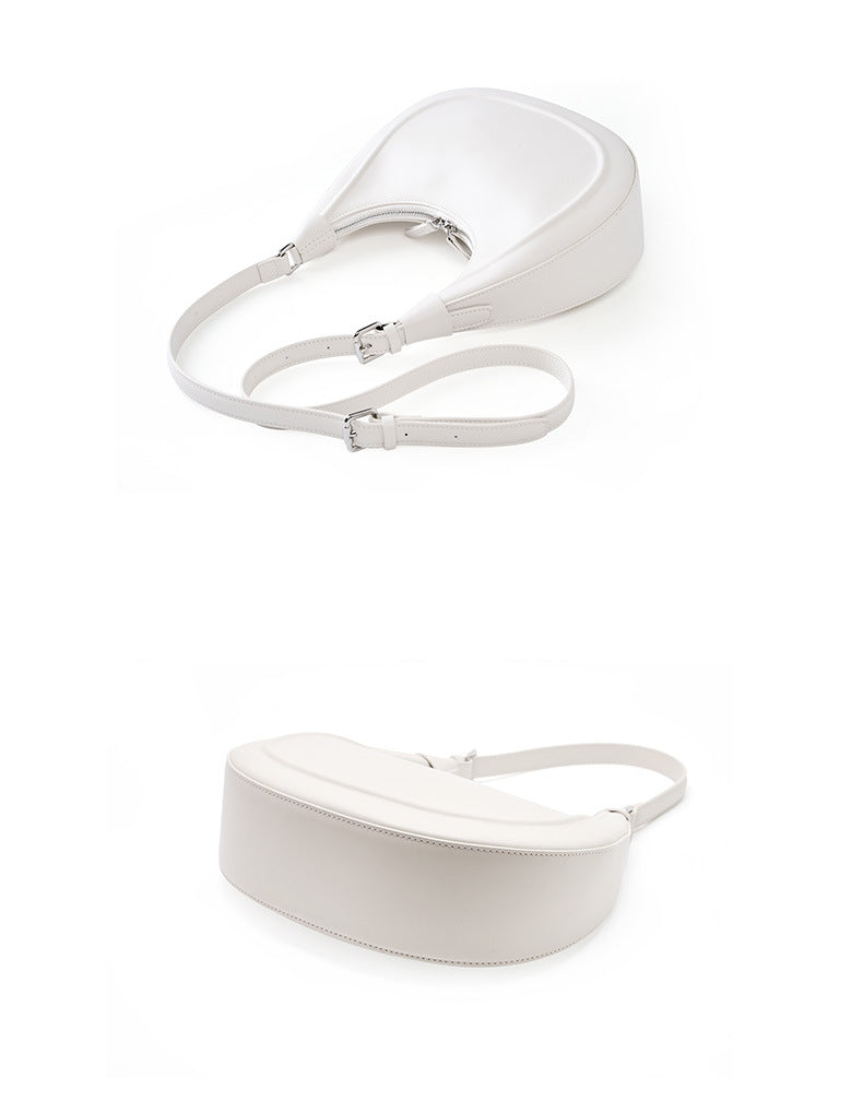 Cream white crescent bag shown flat with the extender crossbody strap