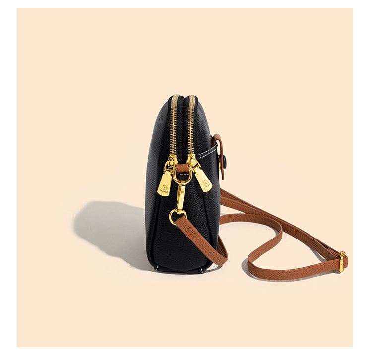 Profile view of black phone bag highlighting two-way top zipper and gold-tone zipper pulls