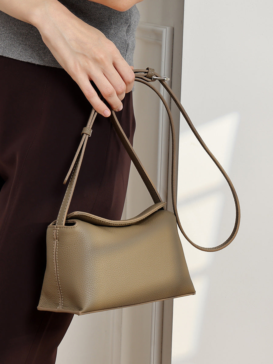 Khaki leather pillow crossbody bag styled with a brown skirt on model