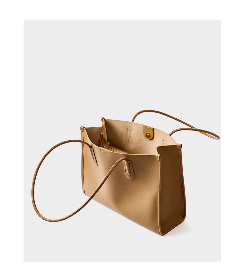Top-down view of golden brown leather tote bag showing the open interior and magnetic closure