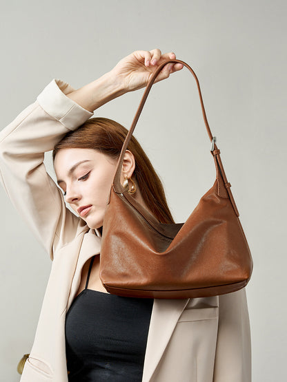 Model carrying a chocolate leather hobo bag over the shoulder