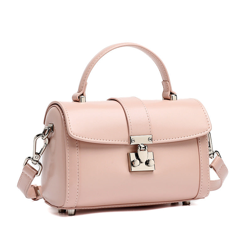 Pink cowhide leather mini box crossbody bag with lock clasp on white background