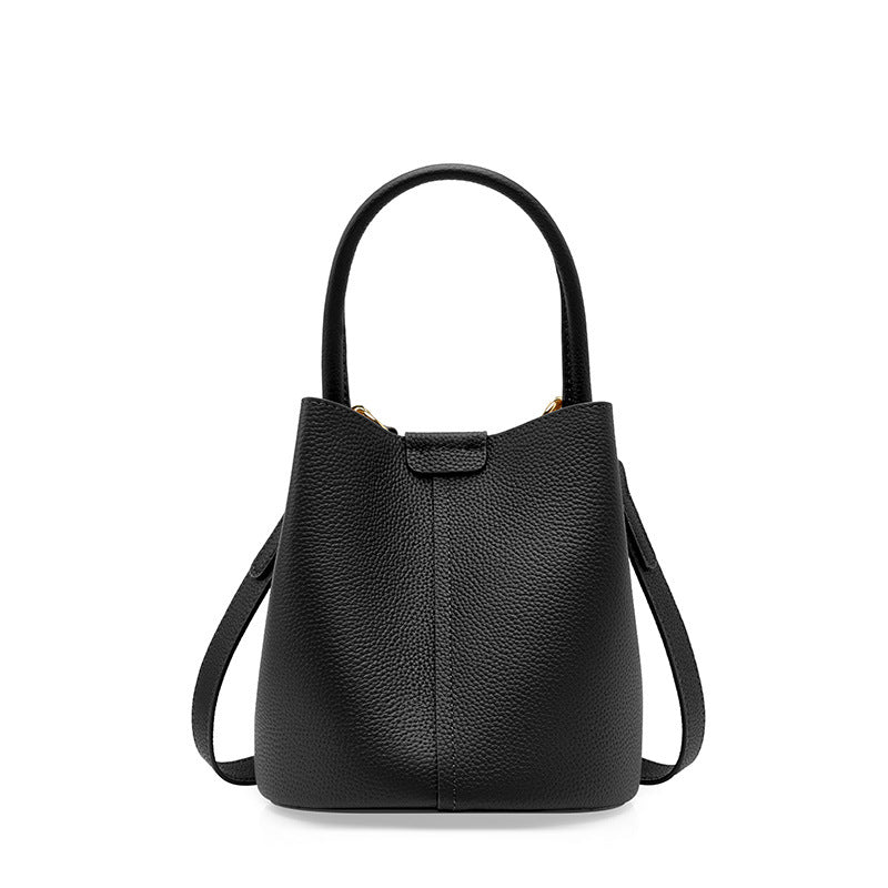 Black pebbled cowhide mini bucket bag with top handle on white background