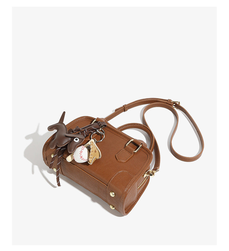 Side view of brown mini bowling bag showing strap and zip closure