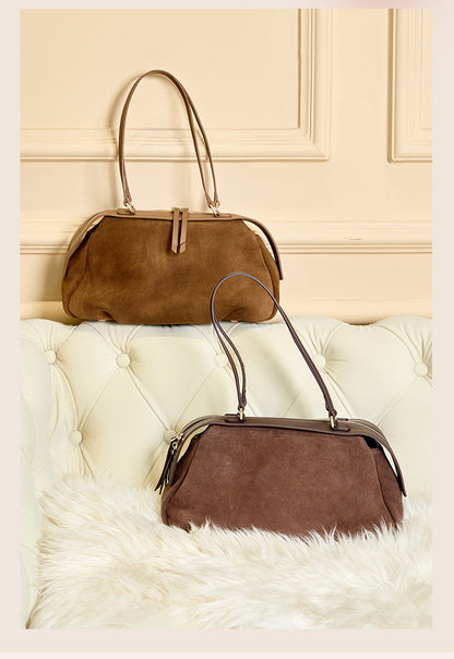 Model holding brown leather shoulder bag