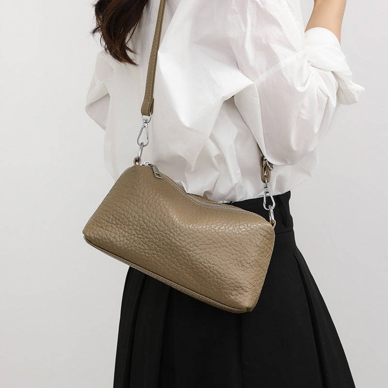 Khaki mini leather bag worn crossbody with a white outfit