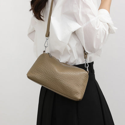 Khaki mini leather bag worn crossbody with a white outfit