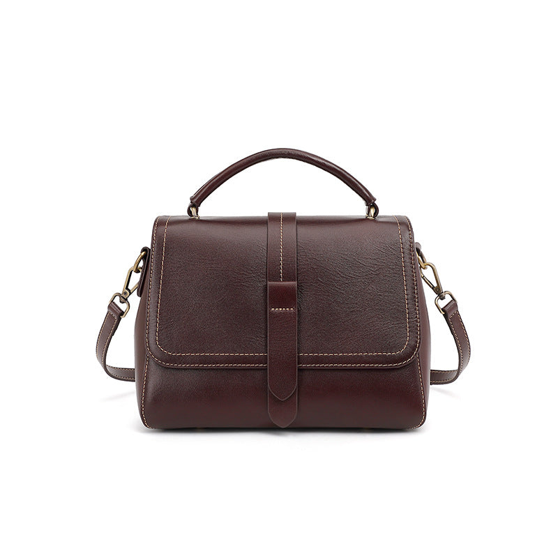 Wine brown cowhide leather Boston crossbody bag with top handle and flap closure on white background