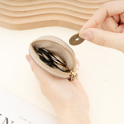 Hand holding open round leather coin purse filled with coins