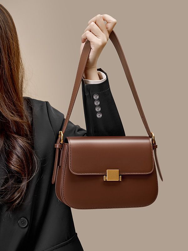 Model carrying caramel leather shoulder bag on the shoulder, lifestyle view