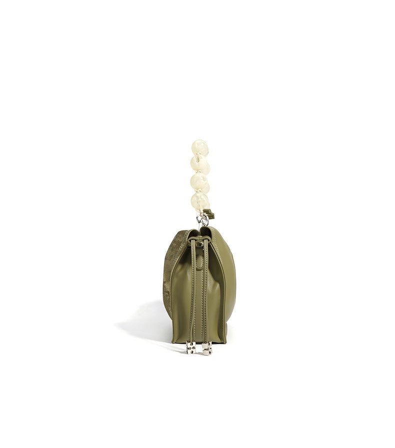 Side profile of sage green mini bucket bag showing drawstring closure