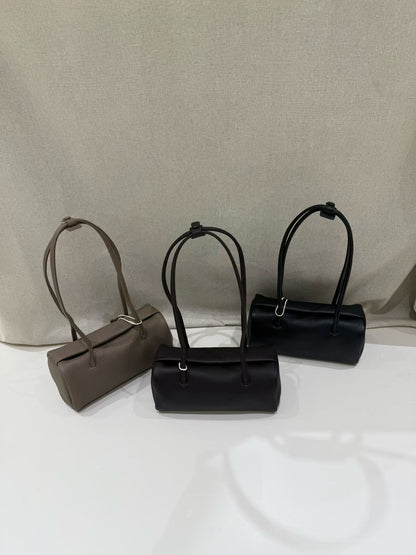 Three pillow-shaped shoulder bags arranged side by side