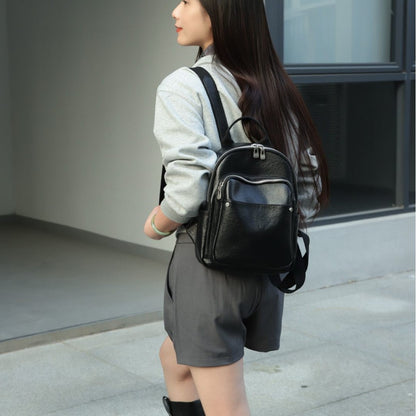 Black cowhide backpack worn over one shoulder