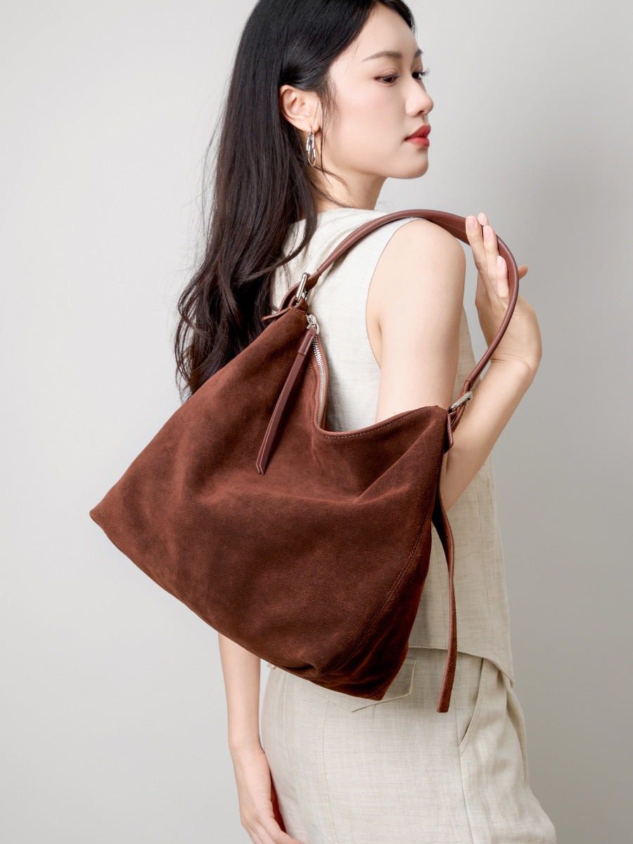 Model carrying the brown tote over one shoulder