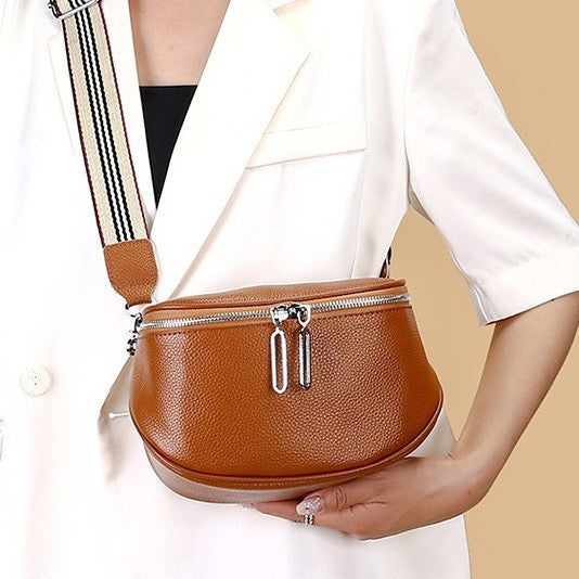 Brown crossbody bag shown worn over a white blazer