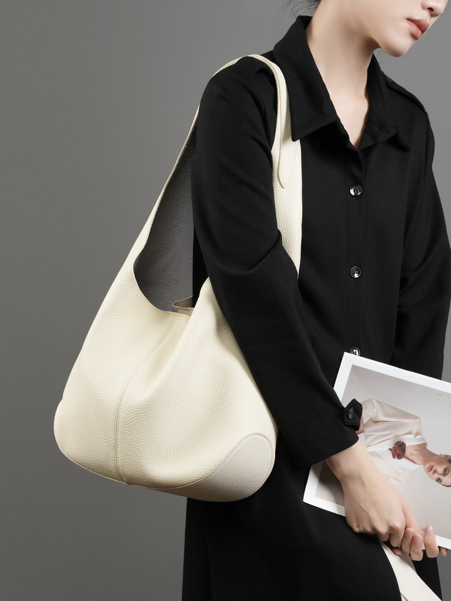 Front view of off-white bucket tote styled with black shirt