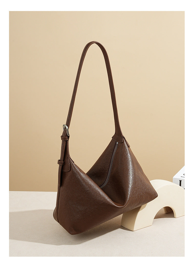 Chocolate cowhide hobo bag shown at an angle with zip closure and shoulder strap