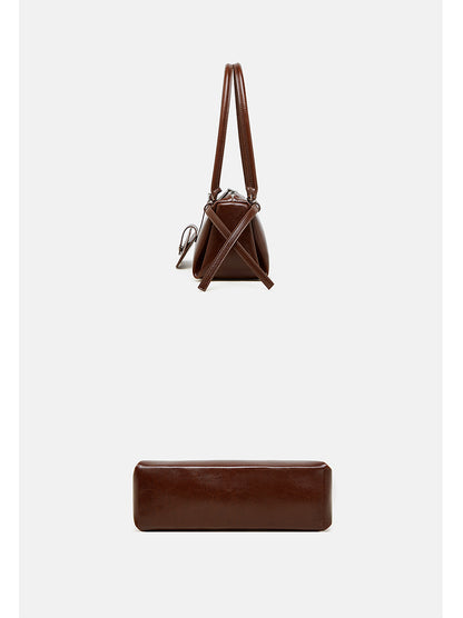 Top-down and side view of brown leather barrel bag showing handle length and base depth