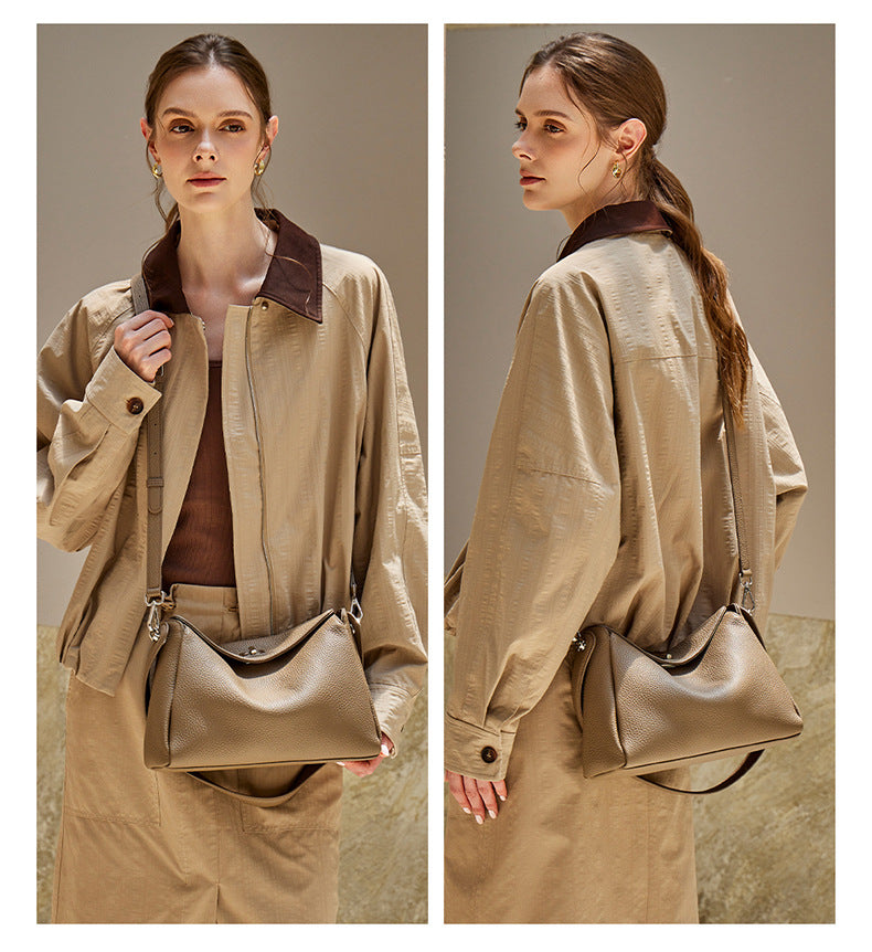 Front and back view of a model wearing a taupe pebbled leather crossbody bag with silver-tone hardware