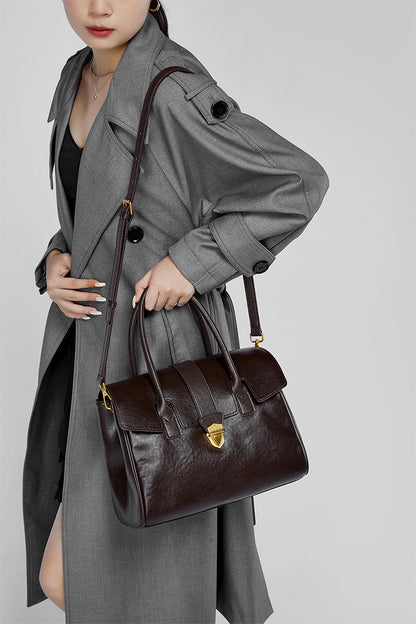 Dark brown leather satchel bag with flap closure and lock clasp