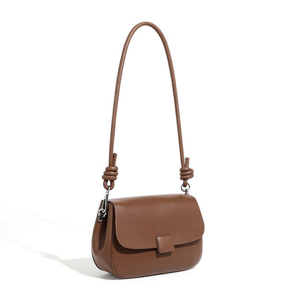Brown cowhide leather compact crossbody bag with turn-lock flap on white background