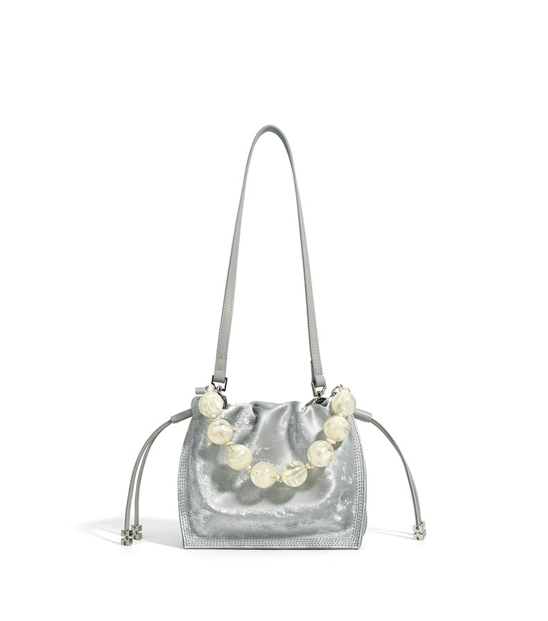 Silver mini bucket bag front view with long crossbody strap extended