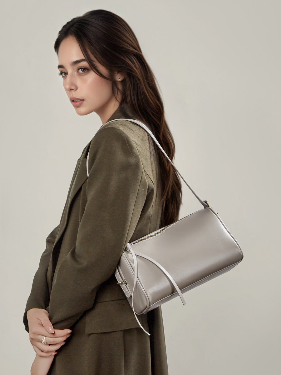 Model wearing light gray leather crossbody bag over the shoulder