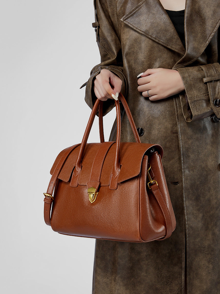 Brown leather satchel bag with flap front and gold-tone lock clasp