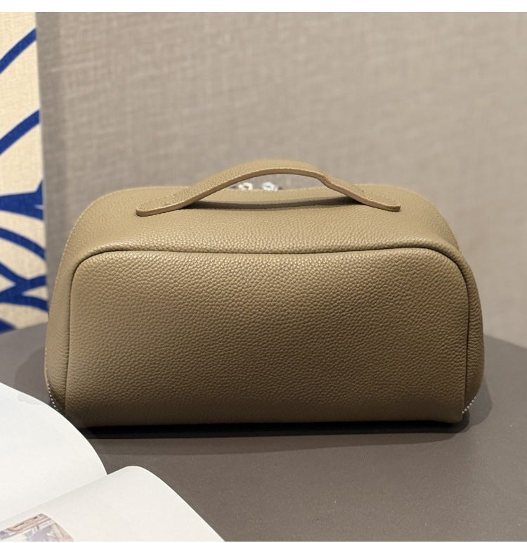 Angled side view of taupe leather pouch and zip closure