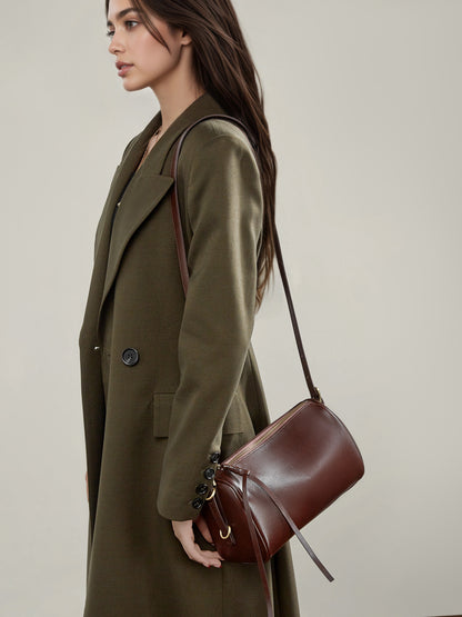 Side view of coffee brown leather crossbody bag worn on the shoulder