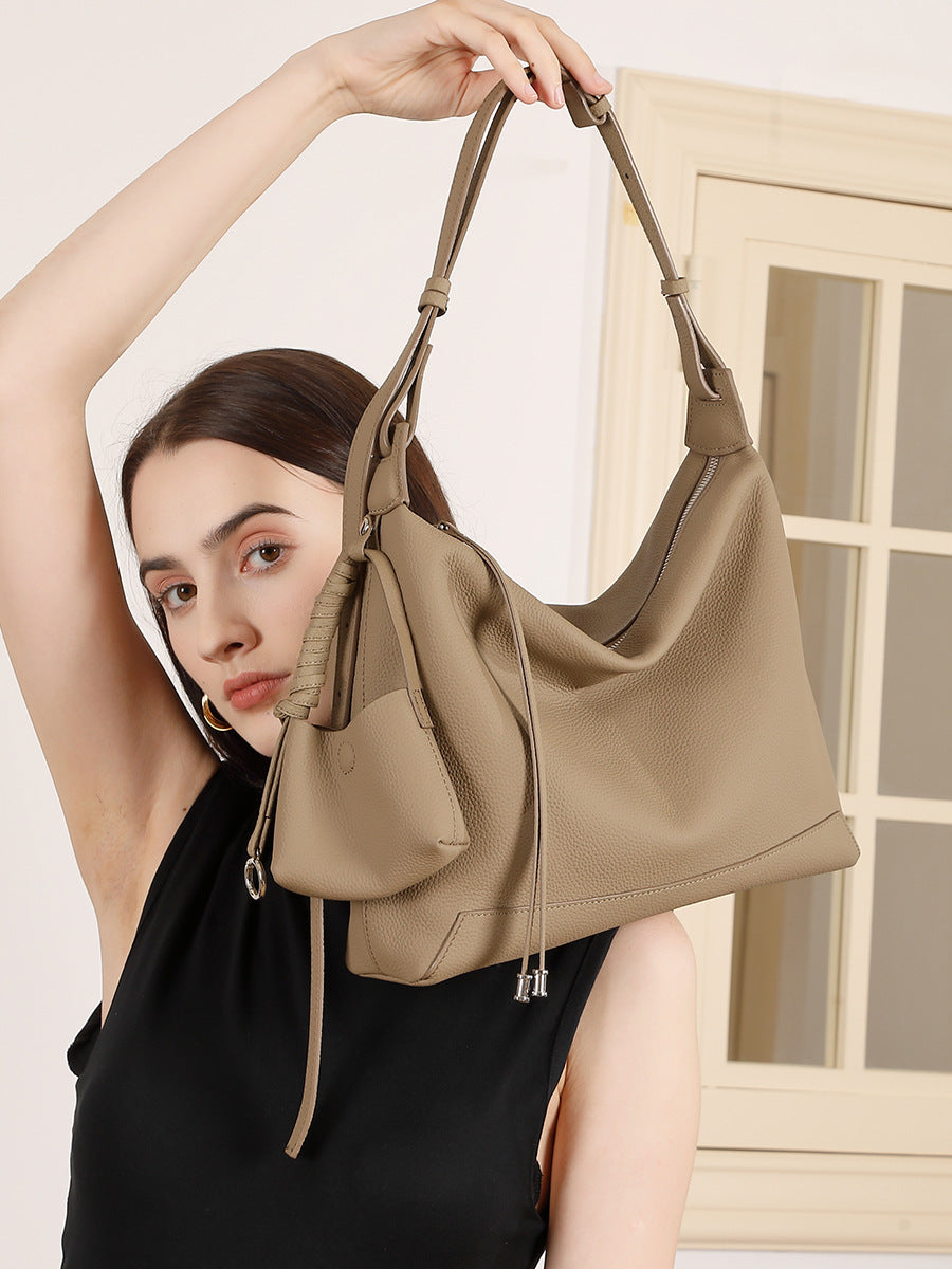 Model wearing gray cowhide leather hobo bag over the shoulder indoors