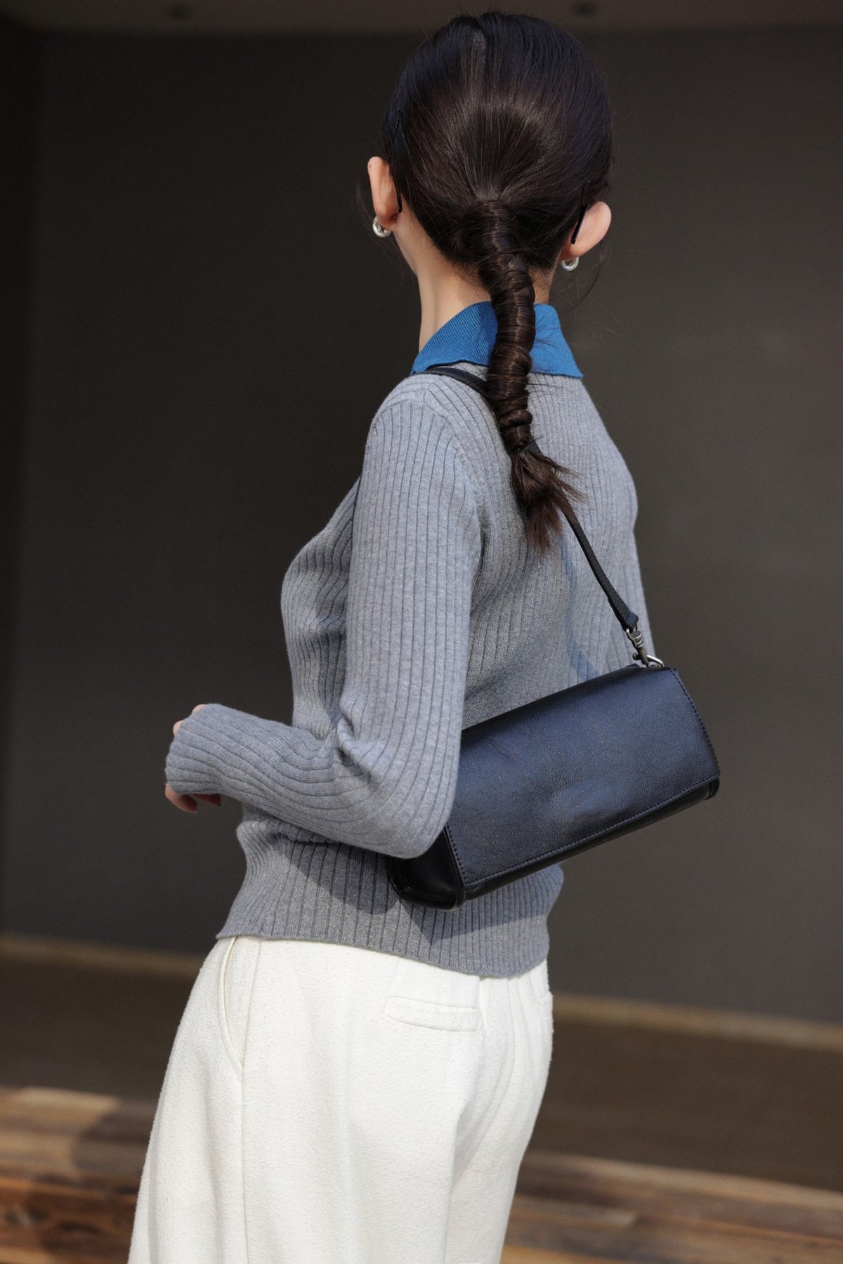 Black cowhide bag shown close-up while being carried