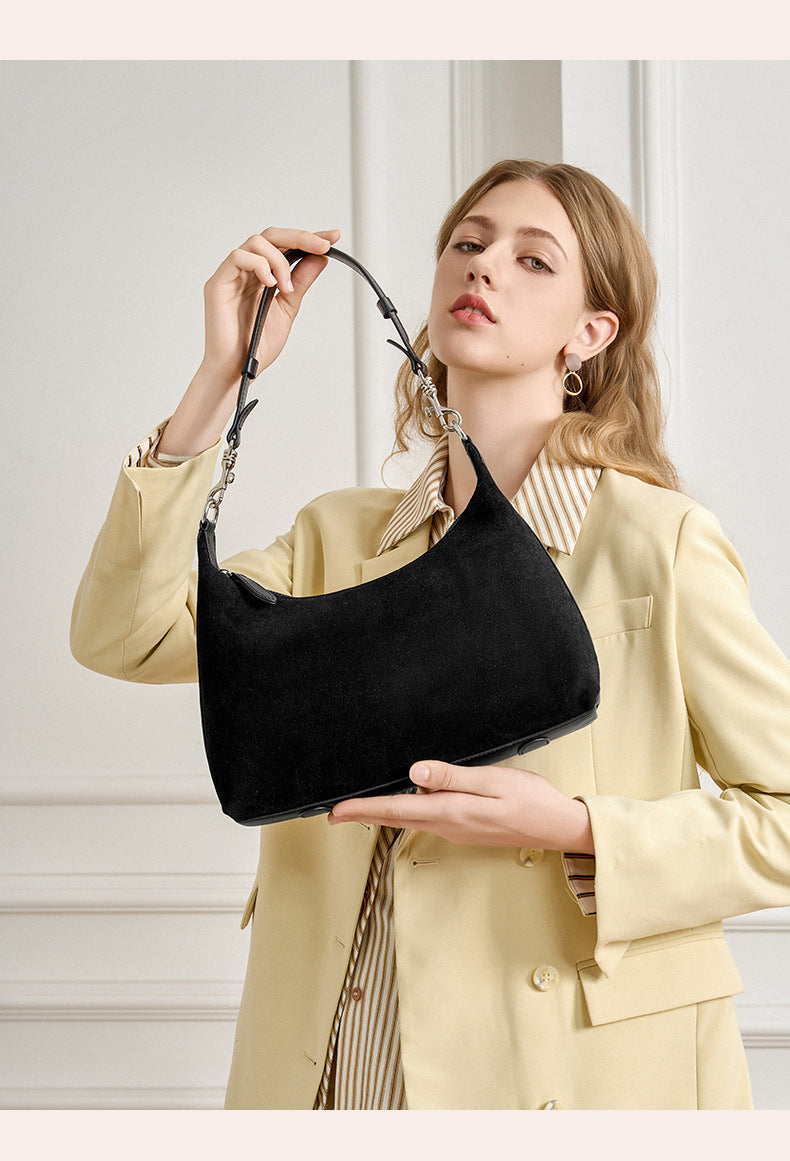 Black version of the suede-finish shoulder bag held in front