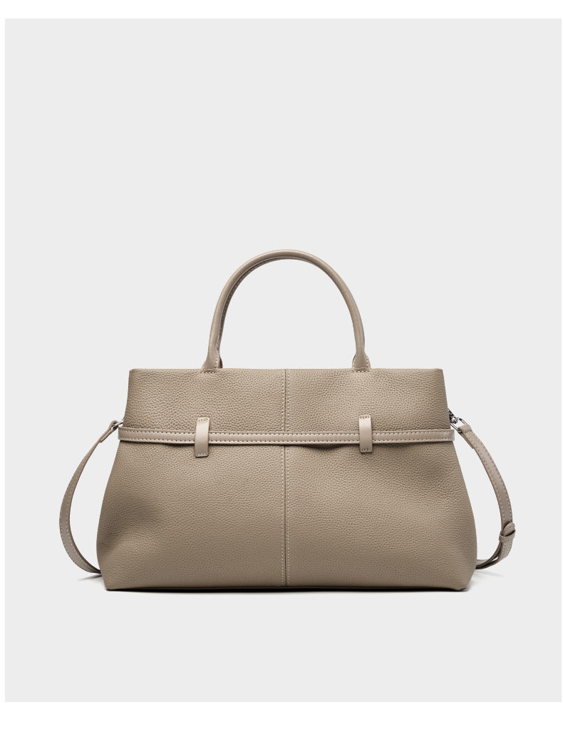 Empty elephant gray leather tote standing upright showing top zip and handles