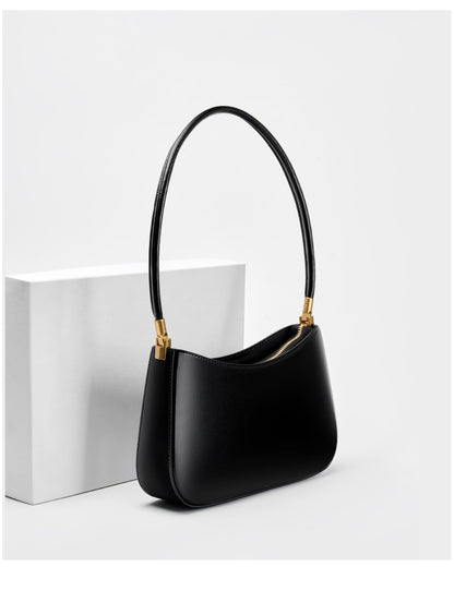 Black shoulder bag shown from a three-quarter angle on a white block