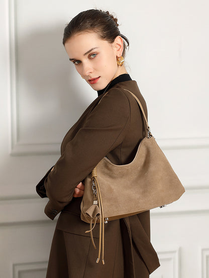 Model wearing gray nubuck underarm tote over shoulder with blazer