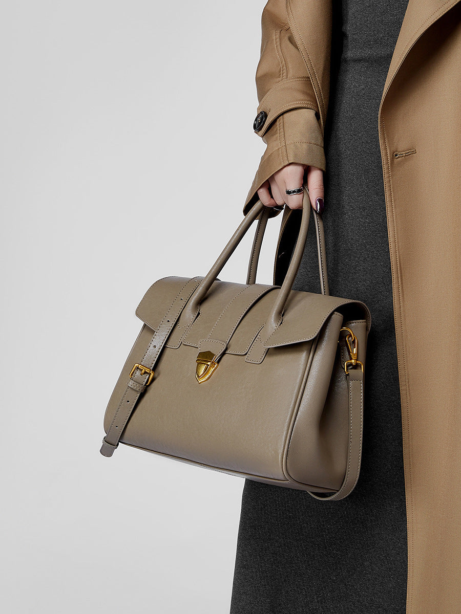 Top-grain cowhide satchel bag in taupe carried by top handles