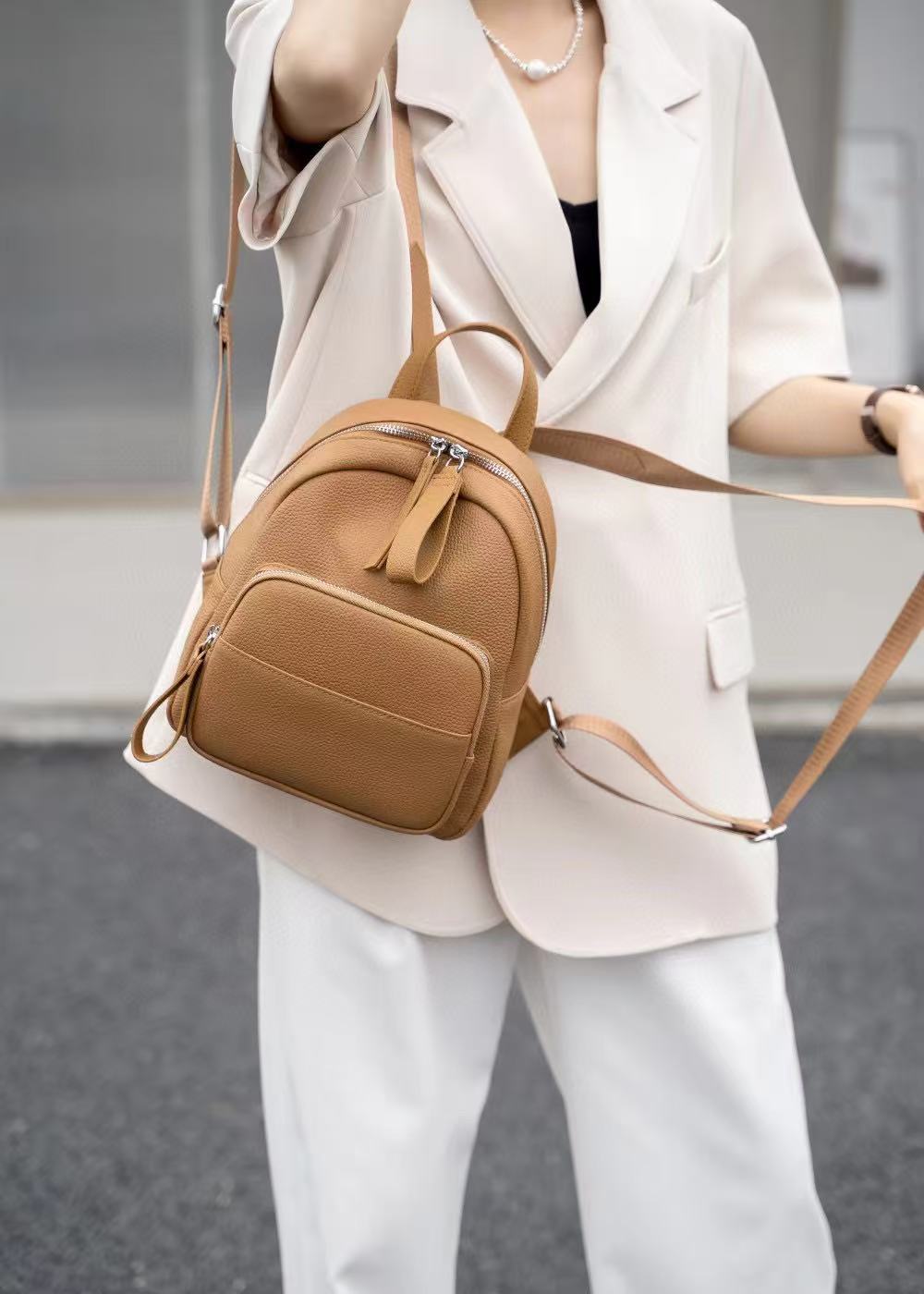 Brown leather mini backpack worn over the shoulder