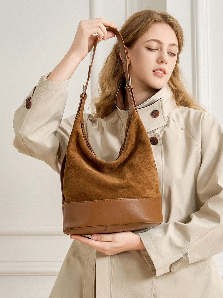 Model holding the coffee leather and suede shoulder bag