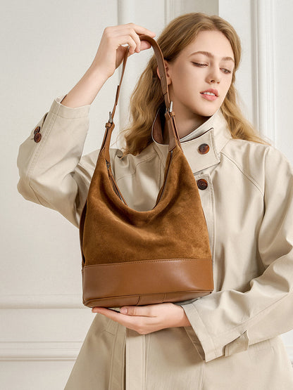 Model holding the coffee leather and suede shoulder bag