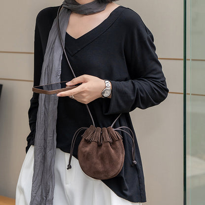 Single shoulder strap on a small leather bucket bag
