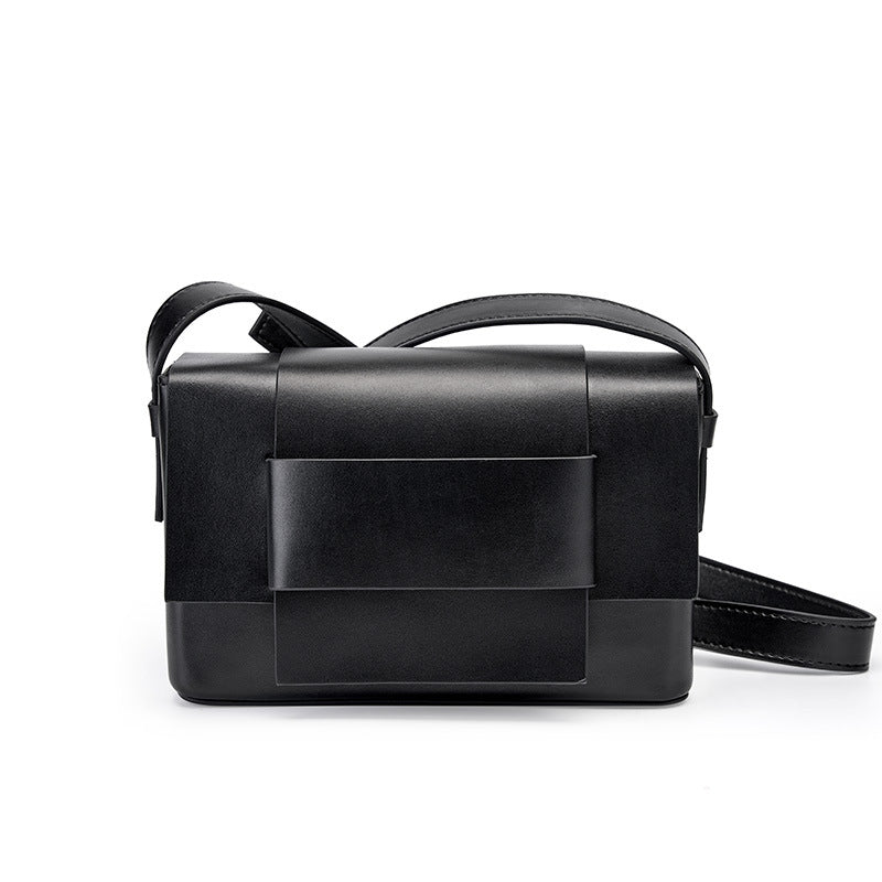 Black cowhide leather mini crossbody bag with bow front flap on white background