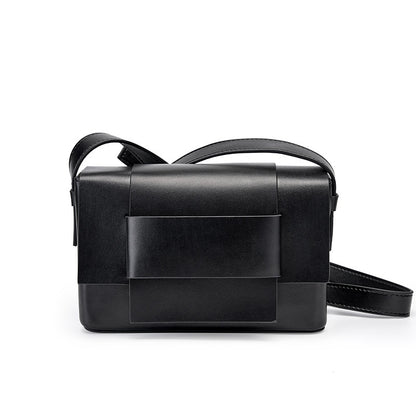 Black cowhide leather mini crossbody bag with bow front flap on white background
