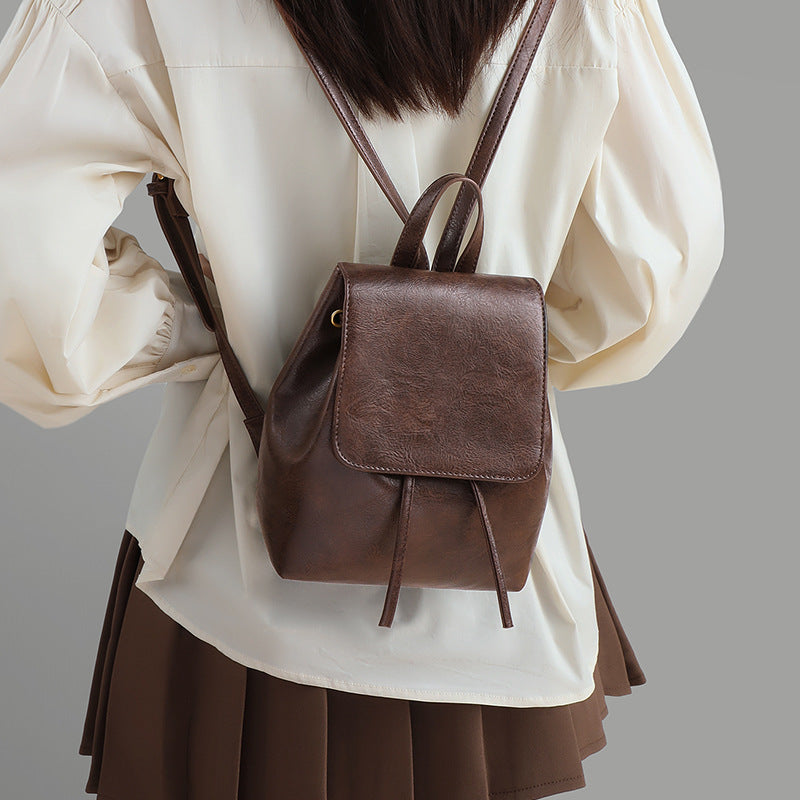 Compact brown backpack worn on the back