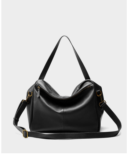 Back view of black leather tote displaying zip closure and adjustable shoulder strap