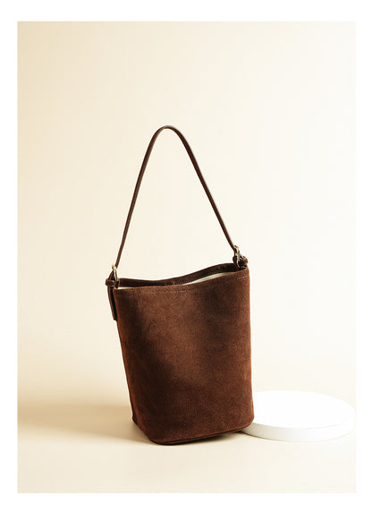 Coffee suede cowhide bucket shoulder bag shown against a light studio background